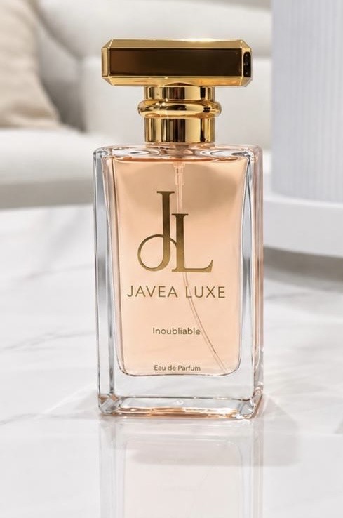 Clear Inoubliable bottle with peach-colored perfume and a gold cap